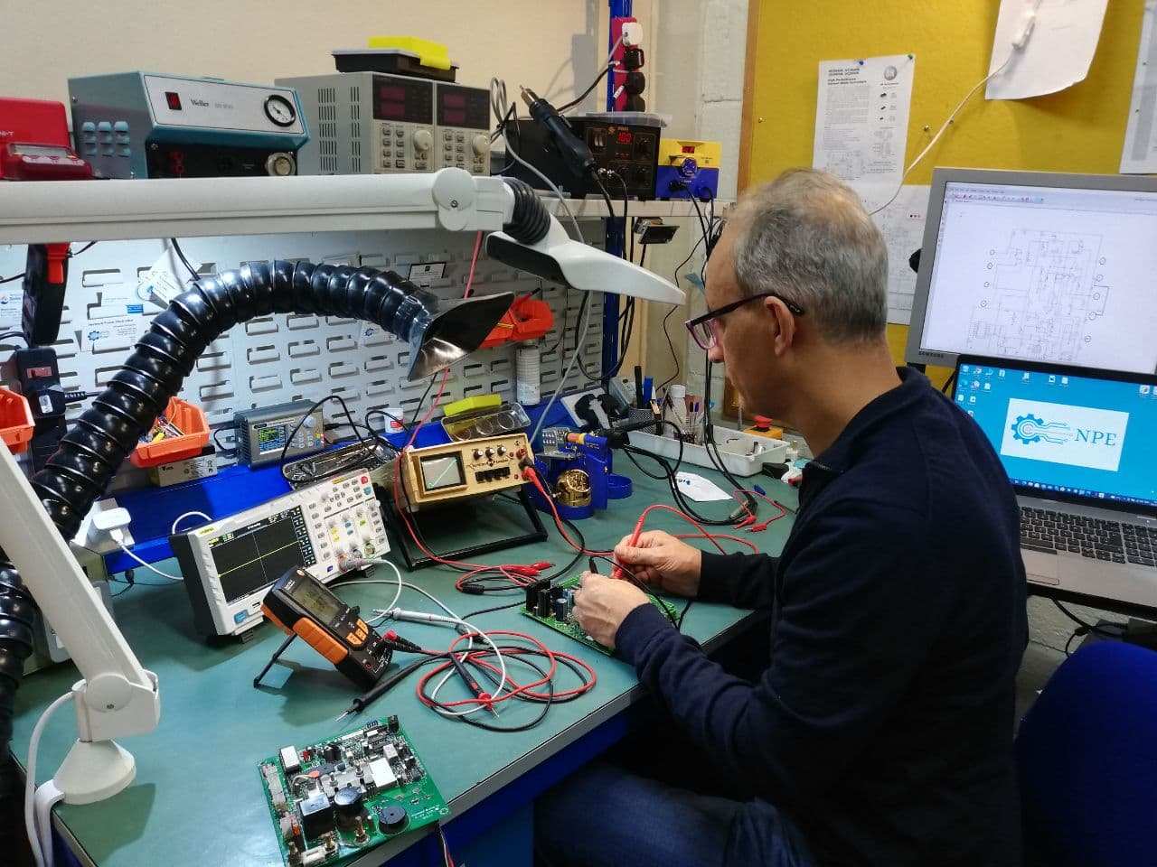 npe engineer testing pcb board with multimeter